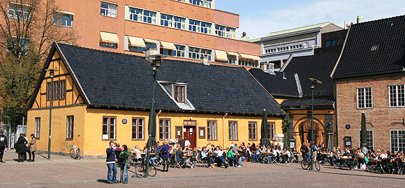An old yellow brick building seen from the square Christiania Torg. 