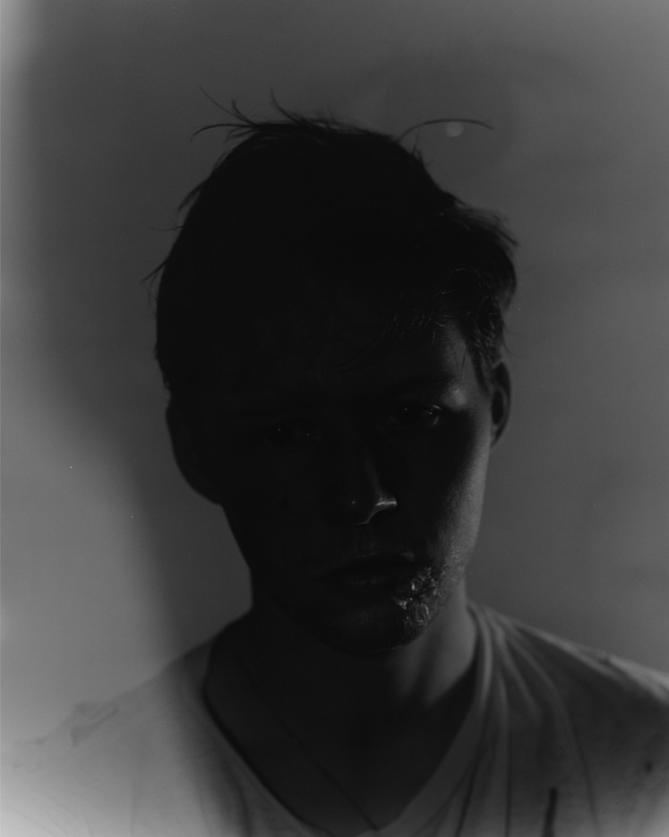 A man in shadow with an eye overlaid.