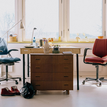 Two office chairs and a work table in a brightly lit studio.