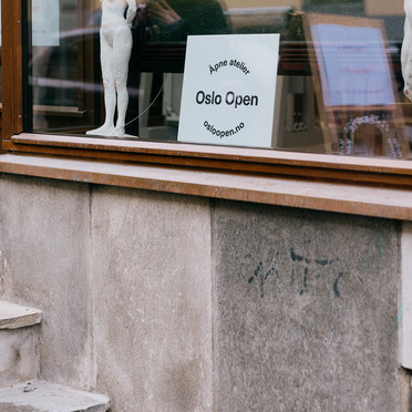 A staircase leading to a studio. In the window, a sign reading: Oslo Open.