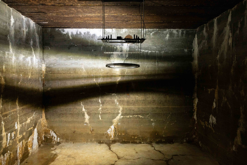 et mekanisk lys apparat projiserer lys og skygger på veggene i en bunker i kunsthall Regelbau411 i Danmark.,