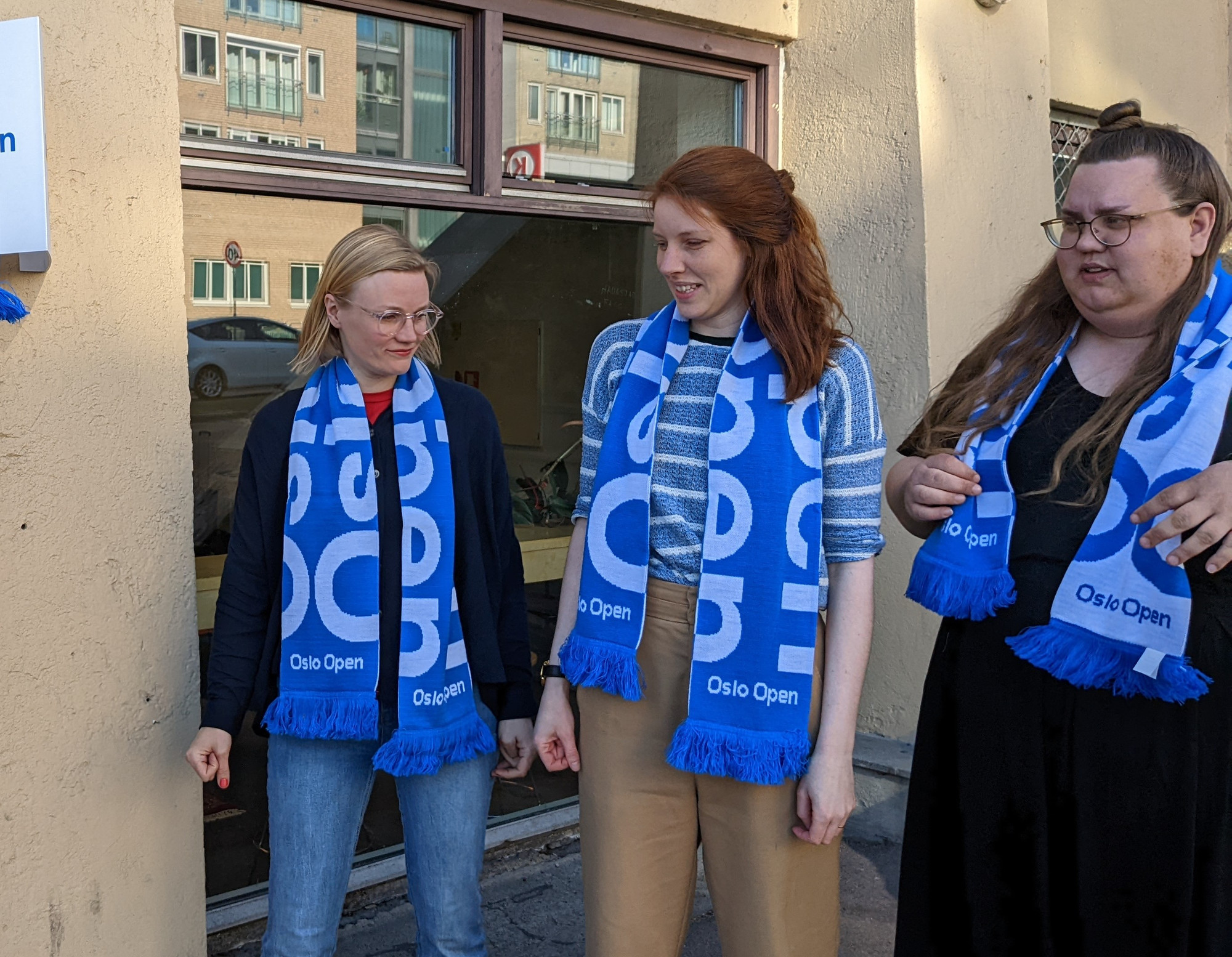 three women in football scarfs looking in different directions